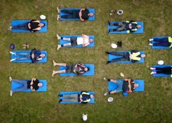 In footage | Development employees switch exhausting hats for yoga mats