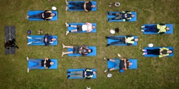 In footage | Development employees switch exhausting hats for yoga mats